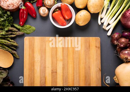 Vue en hauteur de la planche à découper par divers légumes et épices sur fond gris Banque D'Images