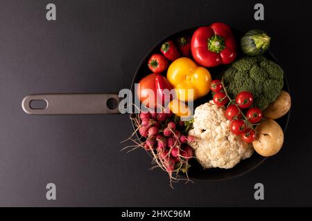 Directement au-dessus de la dose de divers légumes dans une poêle sur fond noir Banque D'Images