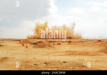 Des nuages de poussière et des pierres volantes pendant l'explosion d'un détonateur dans le désert Banque D'Images