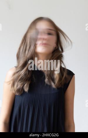 Portrait de fille en robe plissée noire, flou de mouvement Banque D'Images