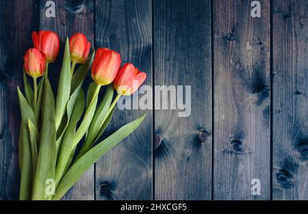 Bouquet de tulipes sur une table en bois sombre. Banque D'Images