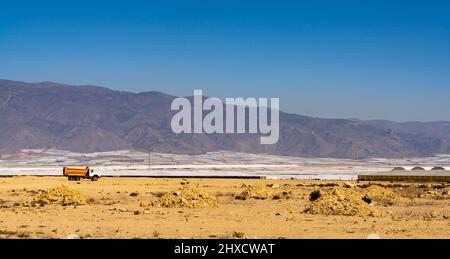 Almerimar, Espagne - 2 mars 2022 : paysage désertique avec de nombreuses serres en plastique et un vieux camion abandonné Banque D'Images