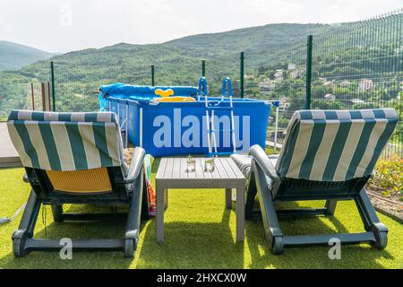 Deux chaises longues avec cocktails sur une table et une piscine à l'arrière-plan Banque D'Images