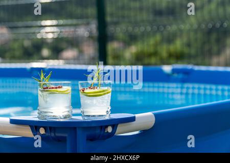 Deux cocktails sur une piscine portable dans un jardin avec vue imprenable sur les montagnes. Banque D'Images