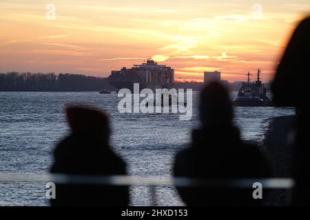 Hambourg, Allemagne. 11th mars 2022. Les passants apprécient le coucher du soleil à Dockland, sur l'Elbe, dans le port de Hambourg. Credit: Marcus Brandt/dpa/Alay Live News Banque D'Images