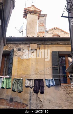 Linge de maison avec des vêtements fraîchement lavés entre les maisons dans un quartier résidentiel de Venise, Italie Banque D'Images