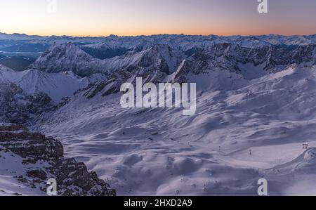 Ambiance matinale sur le Zugspitze, lever du soleil sur la plus haute montagne d'Allemagne 'Top of Germany'. Photographie de paysage. Vue vers Zugspitzplatt, piste de ski. Banque D'Images