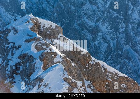Ambiance matinale sur le Zugspitze, lever du soleil sur la plus haute montagne d'Allemagne 'Top of Germany'. Photographie de paysage. Grade anniversaire avec pistes dans la neige. Banque D'Images