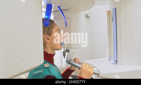 Médecin pour prendre une image scanner 3D tomographie des dents et de la mâchoire dans la clinique dentaire de laboratoire moderne. Une infirmière féminine montre à la patiente une machin à rayons X. Banque D'Images