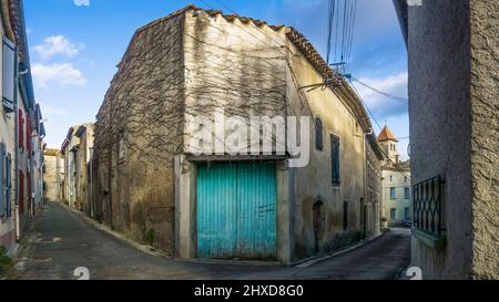 Rue du village à Azillanet avec vue sur le clocher de l'église Saint Laurent. Le territoire municipal appartient au Parc naturel régional du Haut Languedoc. Banque D'Images