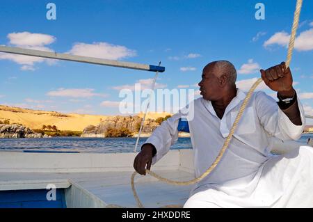 Le bonhomme de mer Nubian navigue son Felucca autour de l'île Elephantine et de l'île Kitchener à Assouan, en regardant vers le désert occidental, Assouan, Égypte Banque D'Images