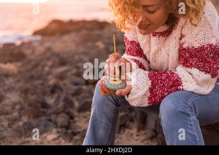 Femme adulte peignant une pierre avec mandala design en plein air de loisirs activité artistique. Bonne femme Profitez de la brosse et des couleurs et créez des œuvres d'art sur des pierres. S Banque D'Images