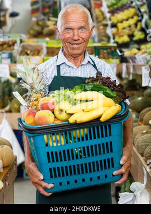 Propriétaire de greengrocery avec panier complet Banque D'Images