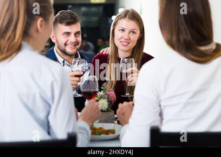 Les hommes avec des femmes élégantes dînent dans le restaurant de luxe Banque D'Images