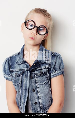 Être original. Portrait d'une jeune fille portant de grandes lunettes rondes posant dans le studio. Banque D'Images