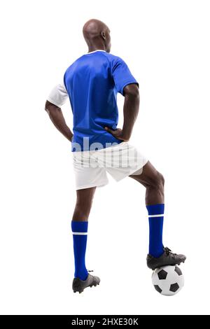 Vue arrière d'un jeune joueur de football américain africain qui marche sur un fond blanc Banque D'Images