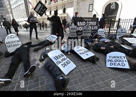 Les manifestants se réunissent devant la Bourse de New York pour exiger que les dirigeants mondiaux mettent fin aux monopoles sur les vaccins COVID-19 le 11 mars 2022 à New York. Banque D'Images