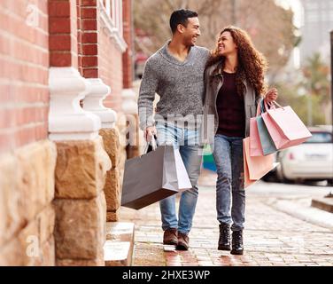 Obtenir un peu de thérapie de vente au détail beaucoup nécessaire. Photo en longueur d'un jeune couple affectueux qui profite d'une frénésie de shopping dans la ville. Banque D'Images