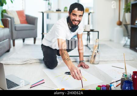 Essayez de créer quelque chose. Photo d'un jeune homme peint en étant assis sur le sol à la maison. Banque D'Images