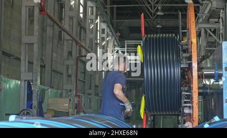 La Russie, l'Angarsk - juin 8, 2018 : le filetage du tuyau de la bobine. Fabrication de tuyaux d'eau en plastique à l'usine. Procédé de fabrication de tubes en plastique sur le ma Banque D'Images