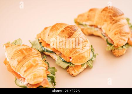 Sandwichs avec poisson rouge et salade sur fond clair Banque D'Images