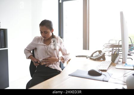 Il est temps pour son traitement à l'insuline. Photo d'une jeune femme d'affaires qui injecte son estomac dans un bureau. Banque D'Images