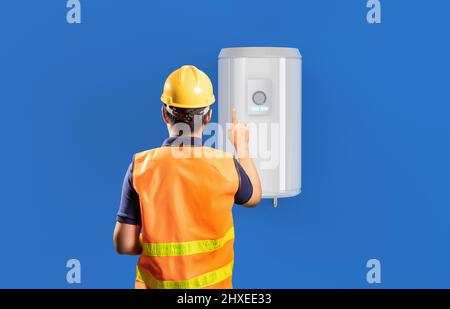 Le technicien vérifie la chaudière ou le chauffe-eau au mur Banque D'Images