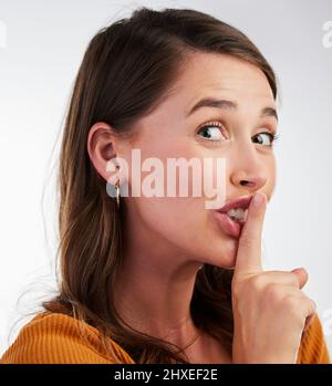 Laisse-le s'écraser. Studio photo d'une jeune femme souriant et signalant d'être calme sur un fond. Banque D'Images