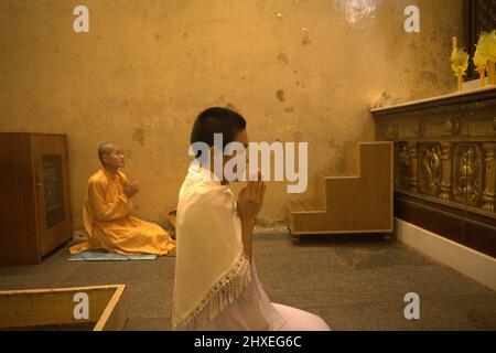 Bhikkhuni (nonnes bouddhistes) prient à l'intérieur de la chambre sainte où la statue du Bouddha d'or est située au temple de Mahabodhi à Bodh Gaya, Bihar, Inde. Banque D'Images