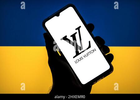 Barcelone, Catalogne. 11th mars 2022. Dans cette illustration photo, un logo Louis Vuitton vu sur un smartphone avec un drapeau de l'Ukraine en arrière-plan. (Image de crédit : © Thiago Prudencio/DAX via ZUMA Press Wire) Banque D'Images