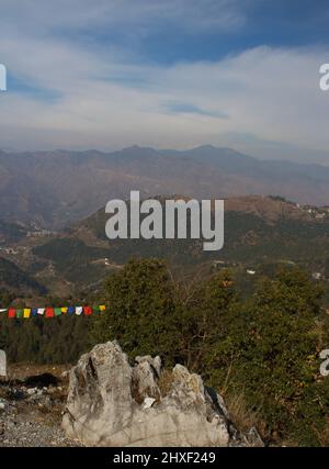 La pointe des chaînes de l'Himalaya remplies de neige sont partiellement visibles en arrière-plan avec des drapeaux tibétains au premier plan Banque D'Images