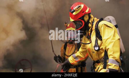 Les pompiers utilisent leur équipement. Attache. Les sauveteurs utilisent de l'eau pour éteindre ou vérifier le fonctionnement de l'inventaire . Banque D'Images