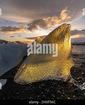 le soleil brille à travers la glace à Diamond Beach, Breidamerkursandur, sud-est de l'Islande Banque D'Images