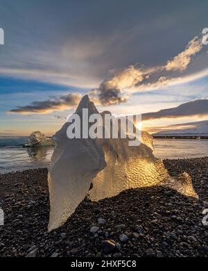 le soleil brille à travers la glace à Diamond Beach, Breidamerkursandur, sud-est de l'Islande Banque D'Images