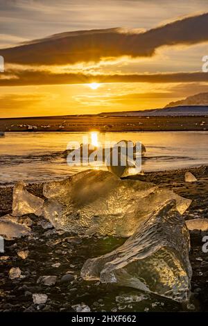 le soleil brille à travers la glace à Diamond Beach, Breidamerkursandur, sud-est de l'Islande Banque D'Images