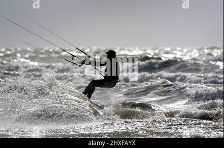 Un surfeur de cerf-volant bénéficie des conditions venteuses de la mer à Camber, dans l'est du Sussex. Date de la photo: Samedi 12 mars 2022. Banque D'Images