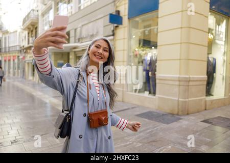 Femme photographe prenant des photos en centre-ville Banque D'Images