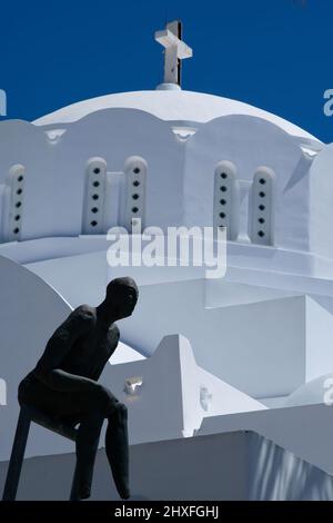 Santorini, Grèce - 10 mai 2021 - une statue abstraite et une église orthodoxe grecque blanchie à la chaux en arrière-plan à Santorini Banque D'Images