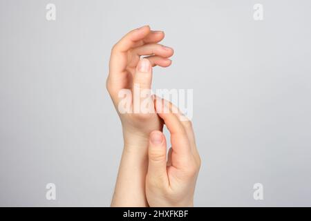 Les belles mains des femmes sur un fond gris clair. Soin des mains, un endroit pour le texte Banque D'Images