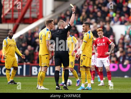 L'arbitre Thomas Bramall présente une carte jaune à Tom Ince de Reading, qui attire lors du match du championnat Sky Bet à City Ground, Nottingham. Date de la photo: Samedi 12 mars 2022. Banque D'Images