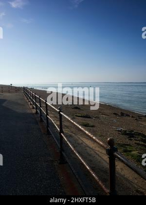 Vue spectaculaire et verdoyante sur le Solent depuis l'île de Wight, sur la plage de galets et la mer ondulée jusqu'aux collines silhouettes du continent. Banque D'Images