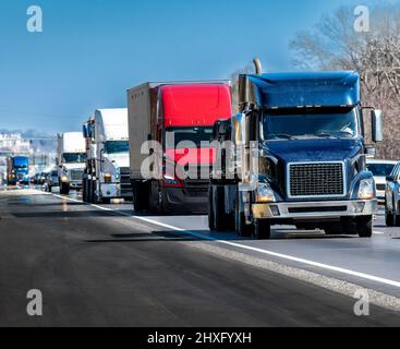 Plan horizontal d'un flux régulier de camions roulant sur l'autoroute inter-États. Banque D'Images
