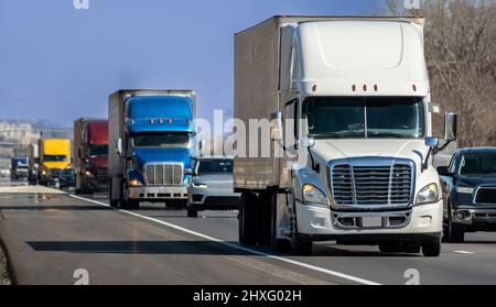 Prise de vue horizontale d'une variété de gros camions à dix-huit roues qui naviguent dans l'Interstate. Banque D'Images