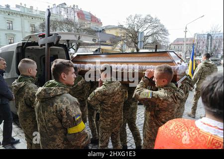 Les militaires ukrainiens chargent un cercueil de l'un des trois soldats ukrainiens tués lors des combats avec les troupes russes dans la catafalque. Une cérémonie funéraire a eu lieu à l'église Saint-Pierre et Paul Garrison pour rendre hommage aux trois soldats : Dmidro Kotenko, Kirill Moroz et Vasil Vyshivany, qui sont morts près de Kherson pendant l'agression russe en Ukraine. Banque D'Images