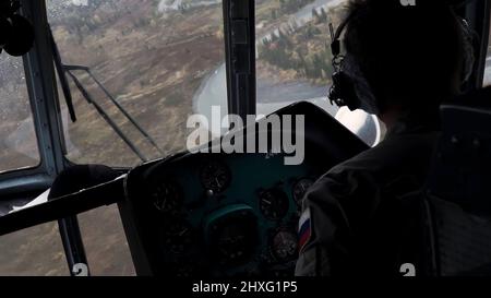 La vue de l'hélicoptère. Attache. Le pilote contrôle l'hélicoptère au-dessus d'une grande forêt verte par temps calme . Banque D'Images