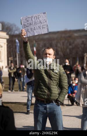 Participant avec signe „Arrêter de bombarder l'Ukraine“. Le 12 mars 2022, des centaines de personnes se sont rassemblées sur la Koenigsplatz à Munich, en Allemagne, pour montrer leur solidarité avec l'Ukraine. Les manifestants ont exigé le retrait immédiat des troupes russes, une solution politique au conflit, le soutien du gouvernement allemand et des sanctions immédiates contre la Russie. (Photo par Alexander Pohl/Sipa USA) Banque D'Images