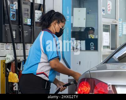 SAMUT PRAKAN, THAÏLANDE, FÉVRIER 20 2022, Un employé de station-service ravitailler une voiture Banque D'Images