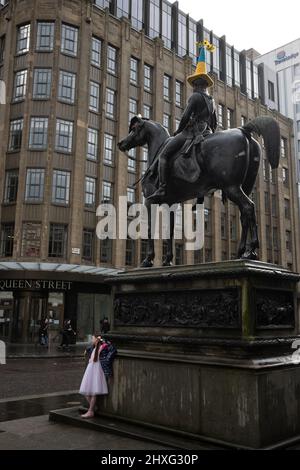 Glasgow, Royaume-Uni, 12th mars 2022. Statue du duc de Wellington dans la rue Queen, portant un chapeau de police bleu et jaune à thème drapeau ukrainien, tel que crocheté par Pauline McWhirter, pour soutenir l'Ukraine dans leur guerre actuelle avec le président PutinÕs Russie, à Glasgow, Écosse, le 12 mars 2022. Crédit photo : Jeremy Sutton-Hibbert/Alay Live News. Banque D'Images