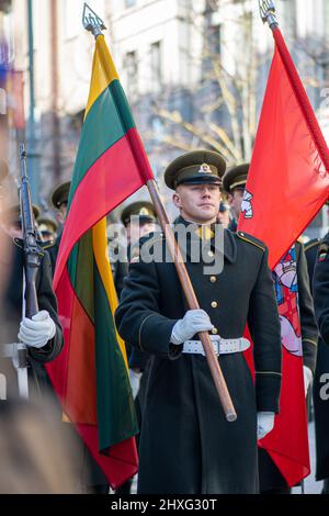 Soldat en uniforme officiel marchant dans les rues de la capitale Vilnius, Lituanie avec drapeaux nationaux, le 11 mars jour de l'indépendance, gros plan Banque D'Images