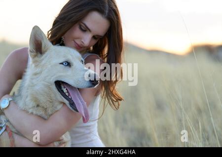 Theres un bon garçon. Photo d'une jeune femme attrayante qui se joint à son chien à l'extérieur. Banque D'Images